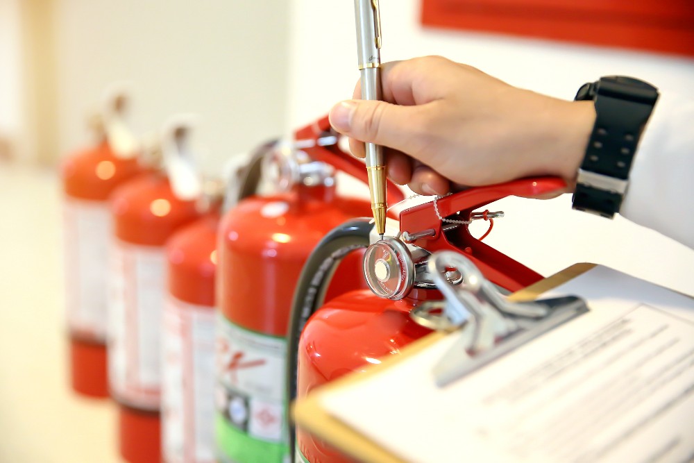 foreground clipboard and hand with pen with fire hydrants in the background